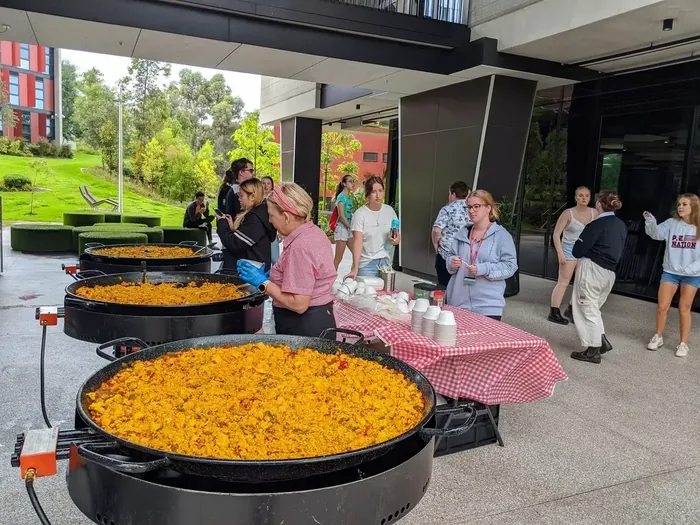 Guests gathered around a live paella cooking station
