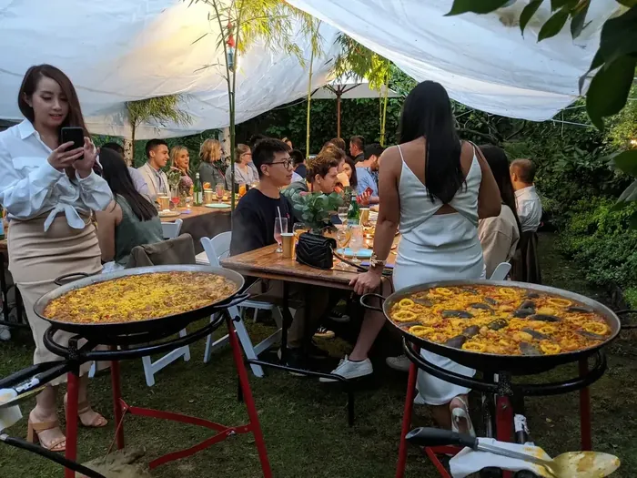 Guests enjoying paella catering at a garden party