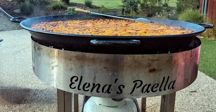 Large paella pan on a branded Elena's Paella catering stand