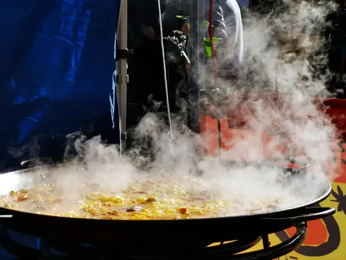 Fresh paella steaming during live cooking
